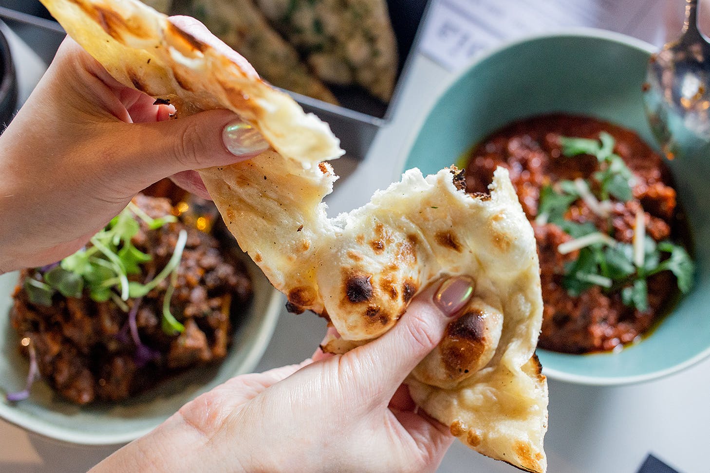We dig into naan bread at Times Of India, one of the best restaurants open this King's birthday in Auckland.